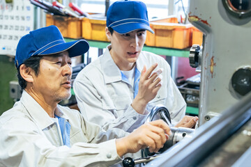 現場リーダーが若手開発者にアドバイスする様子